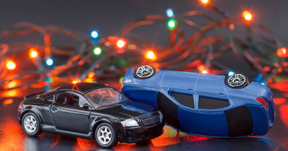 Toy cars crash in front of Christmas lights. | Colling Gilbert Wright