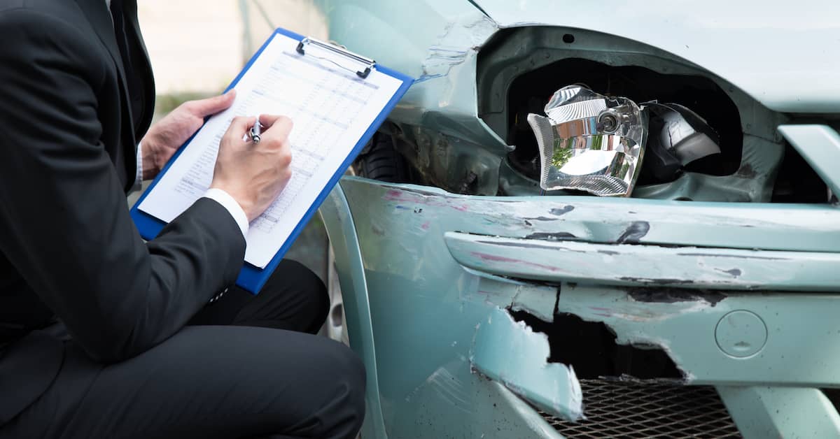 Insurance adjuster assessing damage on car. | Colling Gilbert Wright